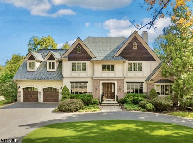 Welcome to 910 Highland Avenue, a beautifully crafted custom Tudor nestled in Westfield's iconic Gardens neighborhood. Set on a picturesque, tree-lined street, this home blends classic architectural elegance with modern luxury. Inside, you'll find arched doorways, domed and coffered ceilings, inlaid oak flooring, and four fireplaces, including one in the authentic oak-paneled library. The spacious layout offers 5 bedrooms and 4.3 baths, along with standout amenities such as a three-stop elevator, a temperature-controlled wine cellar, and an English-style pub bar ideal for entertaining. The gourmet kitchen is thoughtfully designed for both everyday living and entertaining, featuring Viking appliances, custom cabinetry, and a large center island ideal for gathering and meal preparation. A quaint breakfast nook overlooks the property, and the kitchen flows seamlessly into the elegant dining room and sun-filled family room, creating an open and inviting layout. The primary suite serves as a private retreat with a wet bar and refrigerator, a gas fireplace, two walk-in closets, and a spa-like bath with a jetted tub. The finished walk-out lower level provides a private guest suite and expansive recreation space. Recent improvements include a new roof, updated furnace and HVAC units, elevator mechanicals, a new deck, and a Viking refrigerator, dishwasher, and microwave. A rare opportunity to own a distinctive home in one of Westfield's most prestigious neighborhoods.