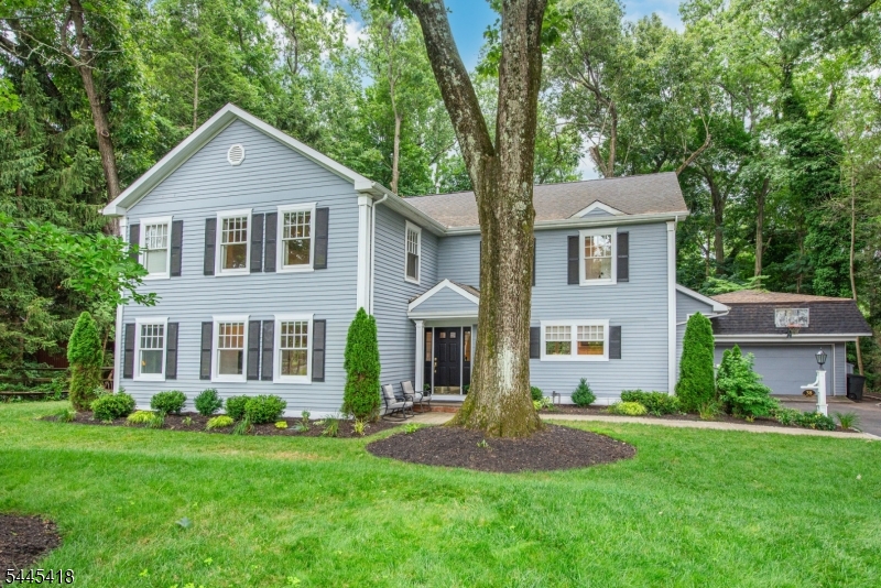 Spacious colonial, expanded in about 2010, with stunning new (2026) chef's kitchen - stainless steel appliances, farmhouse sink, large island with 2nd prep sink, granite countertops opening to dining area and family room with gas fireplace & French doors to patio. Mudroom, 2 PR's, expansive engineered wood floors (several of Manchurian walnut), detailed woodwork, pocket doors, paneling, chair rails & built-ins, 1st Floor in-law suite including bedroom (5), study/sitting area & bath with open shower. 3 large beds on 2nd floor each with en suite bath - especially the huge primary bedroom with majestic high ceiling, sitting area with access to lovely balcony & very large en suite bathroom - plus 4th bed/office. Finished basement, used as a home gym, with full 5th bath, laundry & bonus crawl space ideal for additional storage. Lovely wooded lot with 2 patios and good privacy, just one block from Franklin Elementary School, close to New Providence Train Station, local shopping etc. & all that Summit has to offer including great transportation to New York City via the Midtown Direct Train. This lovely house must be seen inside in order to be appreciated.