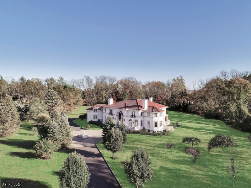 Beautifully designed by renowned architect James Paragano and built to exacting standards by its current owners, this spectacular 10,000 square foot estate awaits visitors at the end of a long gated drive, creating a commanding presence and promising no less. Elegantly framed by sprawling lush lawns and specimen plantings on over 5 tranquil acres, this residence beautifully showcases impeccable attention to detail. The home is voluminous with soaring ceilings and floor-to-ceiling windows, bathing the home and expansive rear terrace in direct southern exposure. Discerning buyers will appreciate the finest quality materials which create a comforting and sophisticated backdrop for life. The home's amenities are impressive including hydronic heating, a sunlit conservatory, gym and over-sized four-car garage.