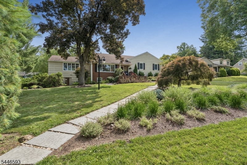 Welcome to this beautifully updated and exceptionally inviting home in the sought-after Convent Station section of Morris Township. A charming front porch and professionally landscaped grounds lead to a light-filled interior with character, including hardwood floors, crown molding, solid-wood doors, many with glass doorknobs, and a handsome fireplace with a newer surround and hearth. The spacious living and dining rooms flow into a crisp white kitchen with granite counters, stainless steel appliances, abundant cabinetry, and under-cabinet LED lighting. French doors open to a sun-filled family room. Upstairs are comfortable bedrooms, updated full baths, and a newly carpeted finished attic offering flexible additional space. At ground level, with additional functionality, you'll find a built-in mudroom bench, a dedicated office with custom desks, a laundry room/powder room, and a garage entry. The expansive finished lower level provides recreation, exercise, and media areas, and a delightful sunporch with both screen and glass inserts offers a relaxing retreat.  Outdoors, enjoy the freshly stained deck, beautiful stone patio, and established landscaping. Major improvements include Andersen Woodwright/400 Series windows, new central air and ductwork in 2025, a new hot water heater in 2026, four-zone hot water heat, and Ethernet throughout. Just a quick jaunt to the Convent Station train, downtown Morristown, and major commuter roads. A wonderful place to proudly call home.