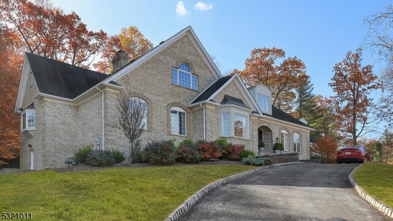 Exquisite 5 BR, 6.5 BA Colonial home with timeless Americana design and architecture.  Full brick facade, large circular driveway, water feature, and mature landscaping provide loads of curb appeal.  Classic double entry doors provide an inviting and impressive welcome to the two story foyer, that is highlighted by a bespoke curved staircase and is filled with natural sunlight.  Warmth and elegance flow throughout the entire property thanks to the artisan wood finishes and refined design elements.  The heart of the home is the sunken living room that boasts a warm fireplace, 2 story vaulted ceilings, and 3 sets of French doors that lead out to the backyard retreat.  The custom chef grade kitchen offers high end stainless steel appliances, and a sun drenched eat in kitchen space that overlooks the beautiful natural surroundings of the property.  A rare main level layout boasts 2 full bedroom ensuites for guests or multi-generational living.  The upper level primary bedroom, is a peaceful sanctuary with epic tree filed views, and is highlighted by a massive sitting room, 3 walk in closets, and a spa like en suite complete with a jacuzzi tub and skylight.  The fully finished lower level offers walk out access to the backyard, a full bathroom, gym space, theater area, wet bar and kitchenette, and plenty of room for recreation and hobbies.  Decompress and soak in the serene views of the fully fenced in backyard, that offers privacy thanks to its mature landscaping and wooded lot.