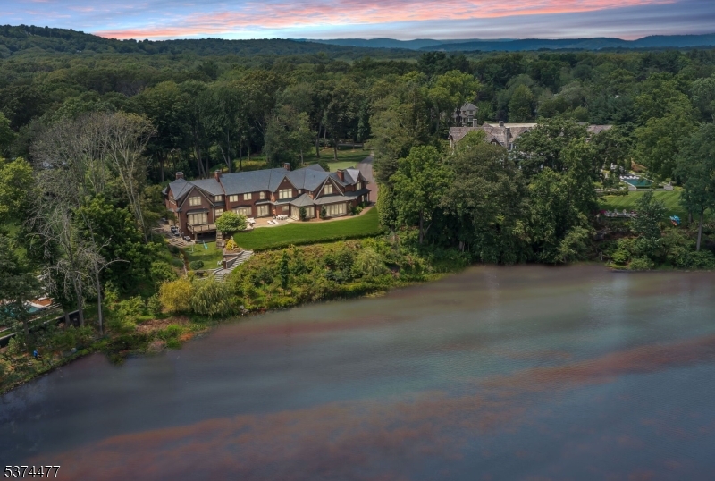 Where Dreams Touch the Water! Welcome to an extraordinary lakefront view estate where timeless beauty meets tranquil living undoubtedly one of Franklin Lakes' most captivating treasures. Set on 2.7 magical acres along the shimmering shores of Franklin Lake, this enchanting all-brick  Manor was thoughtfully designed as a creation of elegance & warmth. From the moment you arrive, peace & quiet grandeur surrounds you. The slate roof, curved lines, & graceful architecture speak to a home built not just with materials, but with intention. Inside, a story unfolds across 13 rooms of refined comfort & charm. Curl up with a book in the richly paneled great rm/library, gather by the fire in the sunlit grand living room, savor mornings in the breakfast room, wrapped in light with breathtaking lake views. The heart of the home an artisan kitchen with twin islands & handcrafted details opens to a 24x31 family room with a wall of windows. Upstairs, the primary suite is flooded with light, framed by nature, & enhanced with his & her dressing room/closets & exquisite marble bath & steam shower. A walk-out lower level is pure joy offering spaces to play & gather from the game/media rooms to a Pub room with wet bar. A heated driveway welcomes you home in every season, while the grounds invite morning coffees overlooking the lake & unforgettable sunset dinners under the stars. This is more than a home- it is a once-in-a-lifetime chance to have land, light, & luxury a true sanctuary by the lake!
