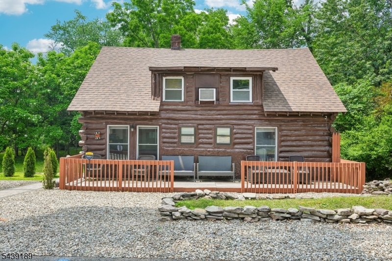 Welcome home to this authentic Log Cabin retreat nestled on a picturesque wooded lot in the heart of Wayne. Blending rustic charm with everyday convenience, this unique home offers the warmth and character just minutes from Wayne's shopping, dining, parks, and NYC transportation. The inviting front porch provides the perfect place to enjoy your morning coffee, reconnect with guests, or simply take in the peaceful surroundings. The side entrance welcomes you into the kitchen featuring custom cabinetry, ample countertops, and stainless steel appliances. The kitchen flows seamlessly into the dining room, where large windows and a wood-burning stove create a warm and inviting atmosphere for everyday meals or memorable gatherings. Beyond the dining room, discover the spacious living room, ideal for relaxing by the fire or entertaining guests. A home office, laundry area, and full bathroom complete the first floor. Upstairs, the primary bedroom offers a comfortable retreat with a generous closet. Two additional bedrooms, sitting room, and powder room provide flexible space. The full unfinished basement offers storage and future possibilities. Step outside onto the rear deck, perfect for outdoor dining, grilling, and enjoying nature. Surrounded by mature trees, the scenic property offers a peaceful setting for recreation, gardening. Experience the best of both worlds with the timeless appeal of log cabin living and the convenience of everything Wayne has to offer.