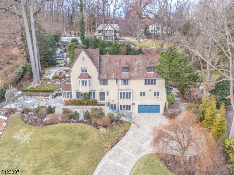 Magnificent French Norman home originally designed in 1929 by renowned architect Francis A. Nelson. complete interior, exterior and landscape renovation in 2012. Nearly an acre of property, over 5000 SQFT of living space set high on First Mountain and offering privacy, convenience and NYC skyline views. Short distance to Upper Montclair village center, NYC Midtown Direct trains and buses. Each room has been meticulously modernized without compromising the architectural integrity of this historic home. All modern custom kitchen, including Bertazzoni, Subzero, Liebherr, and Miele Appliances and large calcutta marble island. Spacious living and media room with full wet bar and fireplace. Living room offers carved limestone, gas-fired wood fireplace with adjacent sunroom. Media room includes wet bar, gas fireplace and beverage center as well. 2nd Floor has Primary Bedroom Suite with WIC and two additional beds/baths. 3rd floor offers 3 additional beds/baths with large recreation room. Control4 audio/video system to orchestrate home entertainment climate and security. Spectacular grounds surround the home- heated stone driveway with plentiful parking and attached 2 car garage. Outside you will find lower/upper level stone patios with outdoor fireplace framed by two water fountains. Original and new stone walls define the master landscaping plan throughout. Lawns can be enjoyed on multiple levels as well, along with a Rose Garden and grilling area for fine outdoor entertaining.