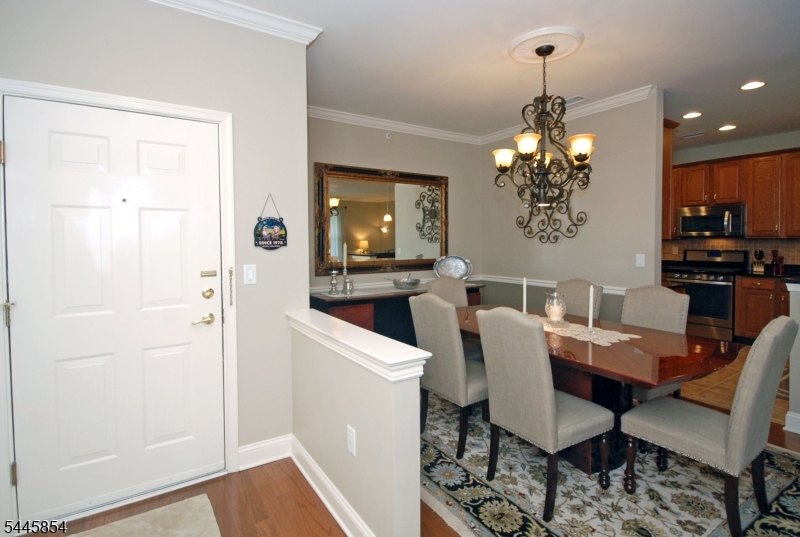 Sought after TOP floor BEGONIA with the high-end upgrades & finishes you desire!   Immaculate and truly turnkey, this home offers a peaceful setting in a 55+ premier gated community.  The floor plan has an open feel designed for privacy between the bedrooms.  A dream kitchen with custom cabinetry, 5-burner stove, granite countertops and backsplash in the perfect blend of colors.    An impressive primary bedroom suite with an accented tray ceiling, sitting area, luxurious bathroom and large walk-in closet w/organizers.  Features upscale lighting, hardwood floors, wood trims, private garage w/storage room and balcony with scenic views of the beautiful grounds.   An outstanding 25,000 sq ft clubhouse with the BEST amenities: indoor & outdoor pool, tennis/pickleball, card rooms, Mahjong, putting/driving, fitness center, grand ballroom, clubs, activities & more. Bordering the town of Montclair with terrific restaurants, theaters, shops & boutiques.  Enjoy luxury living every day!
