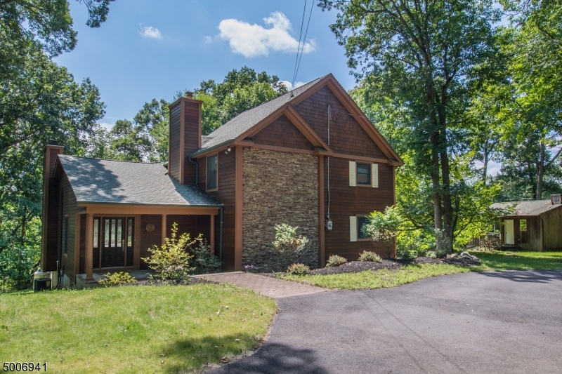 Custom, Renovated Home Beautifully Situated on 1+ Wooded Acre! This unique property offers an impressive home + unfinished space over detached garage to make your very own studio or xtra storage. Main house includes, gorgeous oversized fireplace, wall of windows & french doors, high ceilings all create grand space! Renovated Eat-In-Kitchen offers center island + super sized pantry. The perfect kitchen! All SS appliances, 6 burner stove & wall ovens. Granite counter, cherry cabinets. Organized laundry & wine fridge. Formal dining, great layout for entertaining. Spacious master w/ bath, walk-in & sitting area. Customized closets in bdrms! Expansive finished bsmt; rec room, bdrm & full bath. Detached garage, work room & unfinished space ready to be customized. Close to NYC-Direct transit, hwys, DWTN & schools.
