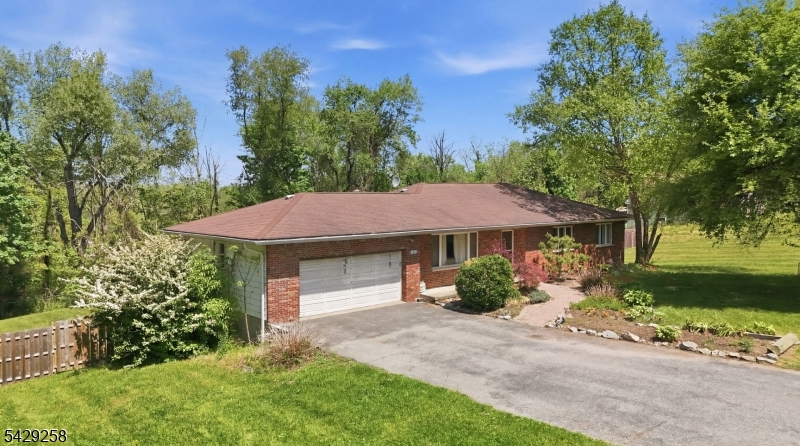 Spacious ranch-style home set on 1.02 acres in Vernon Twp, offering flexible living space, a fenced yard, storage shed, attic fan, and forced-air central cooling. The main level features an inviting living room with laminate flooring, wainscoting, and a coat closet; a formal dining room with recessed lighting; and an eat-in kitchen with wall oven, gas range, center island, laminate flooring, laundry closet, and decorative stone counter detail. The primary bedroom includes laminate flooring, crown molding, double closet, and private full bath with stall shower and tile flooring. Two additional bedrooms offer laminate flooring and closet space. A pull-down attic is located in the hallway for added storage. The walk-out basement provides additional finished and utility space, including a wood stove, sliders, office with egress and double closet, full bath with stall shower, furnace room with natural gas furnace and humidifier, water softener, sump pump, and electric water heater. Additional features include forced-air heat and fenced rear yard. Convenient layout with potential for a variety of uses.