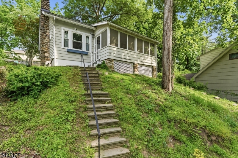 Privacy and charm define this delightful Cape Cod in West Caldwell's heart. The main level features a stunning kitchen with slate floors, butcher-block and honed granite countertops, Brazilian cherry hardwoods, custom woodwork, and stone fireplace. An open concept living and dining area is the gathering place of the home. Enjoy sweeping views from the screened porch overlooking the manicured front yard. Two bedrooms and full bath complete this level. Upstairs, a third bedroom and versatile loft work perfectly as a home office or playroom. The finished lower level includes a family room, full bath, laundry room, and storage room. Recent updates include a new roof, replaced windows and a newer furnace. The private backyard and stone patio are ideal for entertaining or relaxing by a firepit. The 4 car wide driveway is accessible from a deeded right of way from Anita Path. The secluded setting, highly rated schools and a great commuter location make this a gem not to be missed.