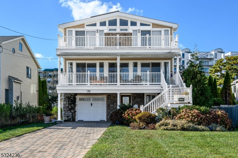 Jersey Shore living at it's finest! Live in luxury in this stunning custom shore Colonial with oceanfront views, right across the street from the beautiful Long Branch beach! Boasting over 3,600 sq ft of sophisticated living space on an oversized private lot with 4 spacious bedrooms, 4.5 baths, 4 gas fireplaces, 1 car garage, full basement, & plenty of windows & skylights that illuminate the space. Enjoy serene ocean views from almost every room, including the light & bright main level and private oversized terrace right off the blissful Master Suite. Gleaming hardwood & tiled flooring, recessed lighting & a crisp palette all through this meticulously cared for home, easy to customize. Living room with gas fireplace and sliders, dining room with gas fireplace, and open gourmet eat-in-kitchen with breakfast bar, granite counters & dinette with sliders to the deck make for seamless entertaining. Upstairs, find 3 generous bedrooms inc the spacious Master Suite. MBR boasts it's own gas fireplace, walk-in closet, walk-out terrace & luxe marble ensuite bath with dual sinks, stall shower, soaking tub & skylights. Addtl full bath & laundry rounds out the top level. Ground level with foyer entry holds 2 full baths, an addtl bedroom & sunsoaked family room with gas fireplace & sliders to the patio. Large, plush backyard with paver patio is fenced-in for your privacy, with ample driveway parking. Just steps to the beach, boardwalk, Pier Village, shops, dining & more! Truly, a MUST-SEE!!