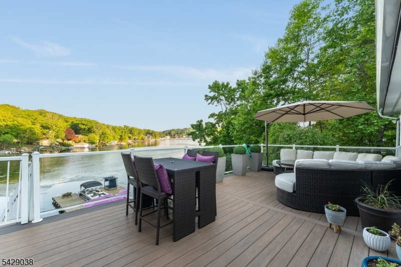 Welcome to the pinnacle of Laketastic living on beautiful Lake Hopatcong! This custom luxury waterfront estate is situated on an impressive 80-ft shoreline in a peaceful no-wake zone. Enjoy calm waters ideal for swimming, paddle boarding , and Boating, offers approx. 3,630 sq ft of living space, including 2,880 sq ft on the main level plus a fully finished walk-out lower level. Designed for true single-level living, all 3 spacious bedrooms are located on the main floor. Unlike many lakefront properties, this home features a rare sloping yard with beautifully terraced entertaining areas leading to the waters edge. A wide sweeping staircase connects multiple outdoor spaces perfect for dining, relaxing, and entertaining. 2 private docks provide secure mooring for up to 7 watercraft, creating an exceptional setup for lake enthusiasts. A private driveway with ample guest parking adds convenience rarely found on the lake. Inside, panoramic lake views fill nearly every room. The spacious walk-out lower level seamlessly extends to the waterfront and outdoor entertaining spaces. A private lakeview office offers stunning 180-degree lake views. Additional highlights include radiant floor heating, central air, whole-house generator, and public sewer. Rare opportunity to own a totally renovated and updated compound on New Jersey's largest lake! Rare opportunity to own a fully renovated and updated waterfront home on Lake Hopatcong!