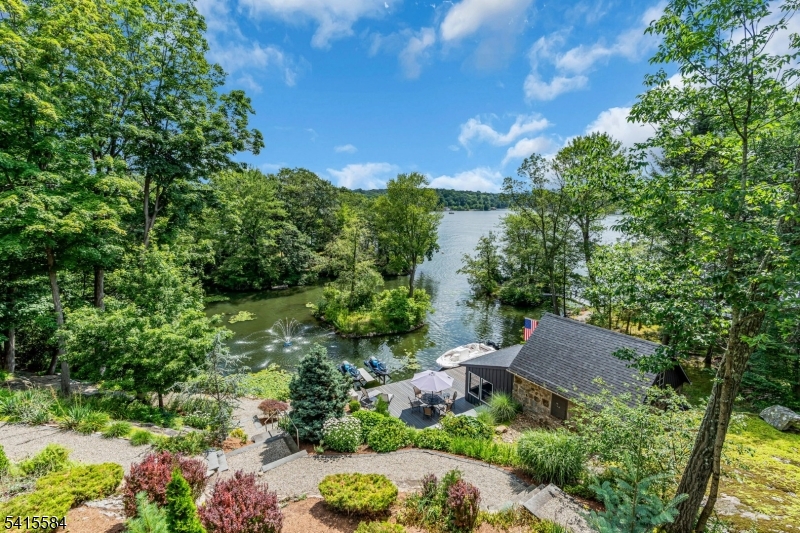 2.52 Acre Lakefront Estate! Renovated, Expanded Ranch with waterside Cabana, 2-story detached garage/barn, plenty of parking & private Islands on a secluded cul-de-sac location! A RARE opportunity to own an extraordinary lakefront retreat offering breathtaking water views over 640 ft of lakefront, exceptional amenities, just one hour from NYC. This beautifully renovated home features an open floor plan with a spacious living room, dining area, and gourmet chef's kitchen with stone countertops and professional-grade stainless steel appliances perfect for entertaining and everyday living. Walls of windows capture spectacular lake views while the upper deck with a screened gazebo provides the perfect place to relax and enjoy the tranquil setting. The full walk-out lower level opens to a stunning slate stone patio, seamlessly blending indoor and outdoor living. Follow the scenic path to your private waterfront dock and lakeside decking, ideal for boating, swimming, and an outdoor kitchen. A charming stone lakeside cabana with a screened area offers a unique waterfront entertaining space. Car enthusiasts and hobbyists will appreciate the impressive detached barn-style garage with loft storage, ideal for additional vehicles, jet skis, or potential future uses. Adding to the magic, the property includes private islands, one with a bridge creating a truly storybook lakefront experience. A one-of-a-kind sanctuary offering privacy, luxury, and unforgettable views.