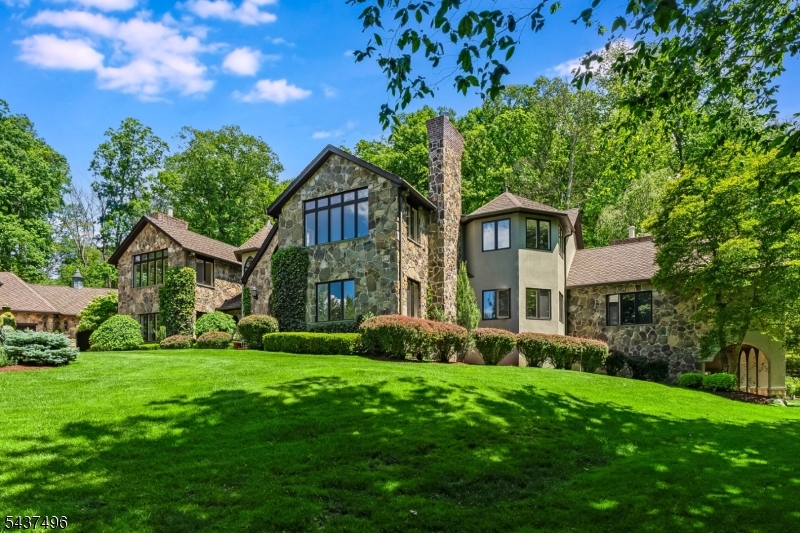 Nestled within the scenic Mendham Borough landscape, this exceptional property presents a stunning 5-bedroom European country residence, meticulously expanded and renovated in 2001 to create an unparalleled living experience. Situated on 6 private acres, this home exudes exceptional craftsmanship and elegance. Inside, the residence showcases extensive custom architectural millwork, wide arched room entries creating an open floor plan, walls of windows that allow for light-filled spaces, random-width hardwood flooring, and a recently updated kitchen. The expansive two-story great room features high ceilings, a stone fireplace, and a wall of French doors offering breathtaking views of the surrounding landscape. The 1st-floor primary suite is a luxurious retreat with a sitting room, fireplace, sumptuous bath, and access to the inviting outdoor sanctuary. The 2nd level provides four bedrooms and three full baths. A two-room suite can serve as a 2nd level primary bedroom. The walkout lower level with living room, kitchenette, exercise room, wine cellar, workshop, full bath, and laundry offers ample space for relaxation and entertainment. An exquisite backyard features a bluestone patio overlooking the recently updated pool with spa and tranquil pond with waterfall feature, creating a magical atmosphere. Shopping, dining & recreational opportunities abound in the area as well as equestrian facilities, nationally-ranked golf courses, and excellent public & private schools.