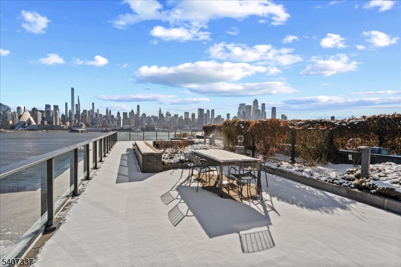 A private Manhattan Skyline Penthouse floating above the Hudson. The highlight of this Trophy Asset is an enormous 1,500 sq. ft. private terrace overlooking the Hudson River an entertainer's dream capable of hosting gatherings of 75 guests or more. 20 Minute drive to Met Life Stadium and Fifa World cup events. Panoramic river and skyline views will leave your guests truly amazed. The primary suite is a private retreat, featuring a spa-like bathroom with a large walk-in rain shower enclosed in glass, an oversized soaking tub with ceiling water flow, and dual vanities. Floor-to-ceiling glass panes throughout the home flood the space with natural light, complemented by over $100,000 in custom, press-button window shades installed by the owner. Residents enjoy an array of luxury amenities, including an ultra-modern gymnasium, rooftop swimming pool, media room, and resident lounge. The gourmet kitchen is equipped with high-end appliances and a built-in wine refrigerator, perfect for entertaining. The unit includes two deeded parking spaces in a gated, secure garage, along with two private storage units conveniently located on the second floor. Terrace garden maintenance is included in the HOA, and all utilities are covered except electricity.