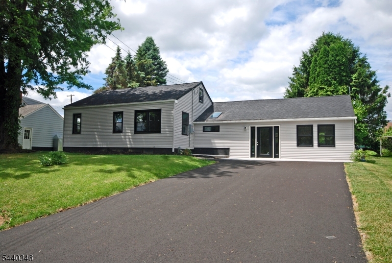 Stunning renovation meets modern comfort in this beautifully updated expanded ranch tucked in a quiet, low-traffic cul-de-sac. Step into a bright great-room style living space with vaulted ceilings, exposed beams, luxury vinyl flooring, and its own mini-split system. The brand-new kitchen impresses with granite countertops, farmhouse sink, stainless steel appliances, subway tile backsplash, and a true vented exhaust hood. A charming dining room with refinished original hardwood floors opens to the backyard through sliders, while three bedrooms also feature refinished wood flooring and share a stylishly updated full bath. The partially finished basement offers a new floor, laundry area, separate playroom or office, and abundant storage, complemented by a walk-up attic with fully walkable space. Major upgrades include new vinyl siding, all-new windows, new plumbing, new 200-amp electric service with full rewiring, a 3-year-old high-end electric water heater, new central air paired with gas hot-air heat, and a 5-year-old furnace. Enjoy a fenced 0.2468-acre property with a new patio, paver entry, and newly paved driveway. Close to shopping, dining, major commuting routes, and minutes from PA this home delivers turnkey living with style and convenience.