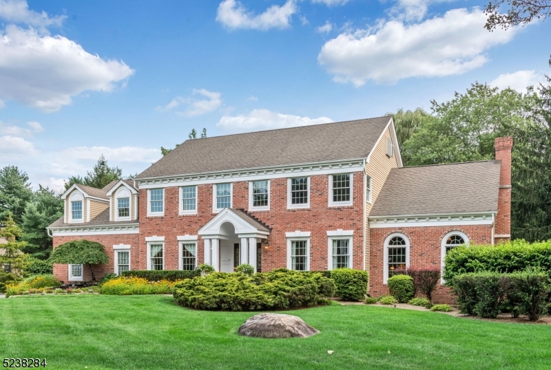 This exquisite luxury home is nestled on a sought-after street, where elegance and sophistication meet nature's beauty. As you approach, a mesmerizing waterfall feature and tranquil pond grace the walkway, setting the tone for the stunning experience that awaits you. This magnificent Center Hall Colonial boasts modern comforts. The attention to detail is unparalleled, with custom woodwork throughout, creating an ambiance of refined luxury. Entertain in style within the Great Room, where 18' ceilings elevate the space, while custom-made corbels add a touch of architectural opulence. As you step outside, a deck with a retractable awning beckons you to the beautifully landscaped backyard oasis. This remarkable property is not only a sanctuary of luxury, but it also offers practicality and convenience. Its commuter-friendly location to NYC ensures you're well-connected while providing a retreat from the bustling city. The outstanding schools further enhance the homes desirability.