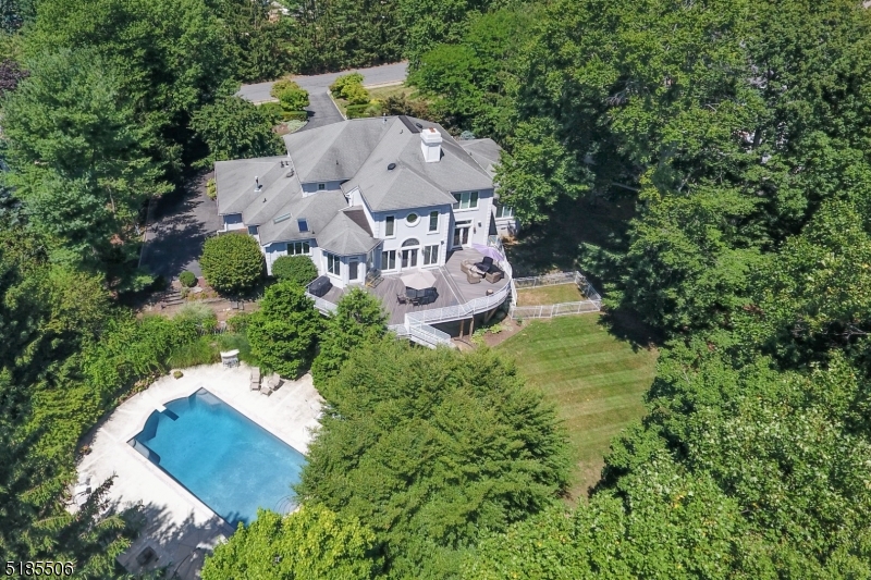 Prestigious Bel Air custom Center Hall Colonial home with approximately 6800 square feet of living space on .8 acres with a spacious backyard and resort-style inground pool provides the ultimate luxury experience. Close to houses of worship, NYC transportation and topnotch schools, this expansive 6+ Bedroom updated custom home boasts exquisite designer finishes everywhere with unparalleled craftsmanship. Circular driveway leads to covered entryway opening to grand 2-story Foyer.  Sunken Family Room features soaring double height ceiling, fireplace, floor-to-ceiling architectural windows. Elegant Living Room and Dining Room. True entertainers' Chef's Eat-In Kitchen with custom high-end counters and appliances, skylights, massive center island, Butler's Pantry + eat-in area with direct deck access and back stairs to 2nd level. 1st Floor Laundry leads to Mudroom and 3-car attached garage. Spectacular 1st Floor Primary retreat with 2 large walk-in closets, sitting area and luxe Bathroom + home Office with fireplace and deck access. Powder Room completes 1st floor. 2nd level features large landing with views of Family Room and Foyer - 3 large Bedrooms + 2 full Baths. Huge Lower Level boasts 2 Bedrooms, a Full Bath, Exercise/Game Room, separate Recreation Room with direct access to the lower patio, pool + 2nd Home Office or 7th Bedroom. Seamless direct access via both the Lower and Main Levels to wrap-around multi level deck overlooking the Resort Style Pool and separate lawn area.