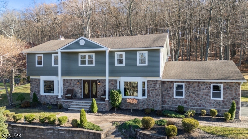 Experience this superbly crafted Stone-Faced Colonial in Denville featuring an Entertainer's Dream backyard in highly sought-after Birch Run neighborhood! Upon entry you are greeted by an Open-Concept Floor Plan with gorgeous hardwood floors flooded with natural light all-throughout. The First Floor features a Family Room with cozy wood-burning Fireplace, an Eat-In Kitchen with Breakfast Bar including Granite Countertops, custom Backsplash & Stainless Steel Appliances, a separate Living Room, Formal Dining Room, and Powder Room. Ascend to the Second Floor where you will find 5 spacious Bedrooms and 2 Full Baths including a Primary Bedroom with a fully renovated En-Suite Bathroom. The Full Unfinished Basement has high ceilings and is your canvas awaiting your design and creativity. The Backyard oasis boasts a private Deck, paver retaining wall, and a BONUS level backyard space backing to green acres allowing endless possibilities ideal for relaxation, hosting, and entertaining. Denville offers Great Schools and is nearby Top-Rated Dining, Grocery Stores, Boutiques, Shops, and much more! Do not miss the opportunity to own your Dream Home!
