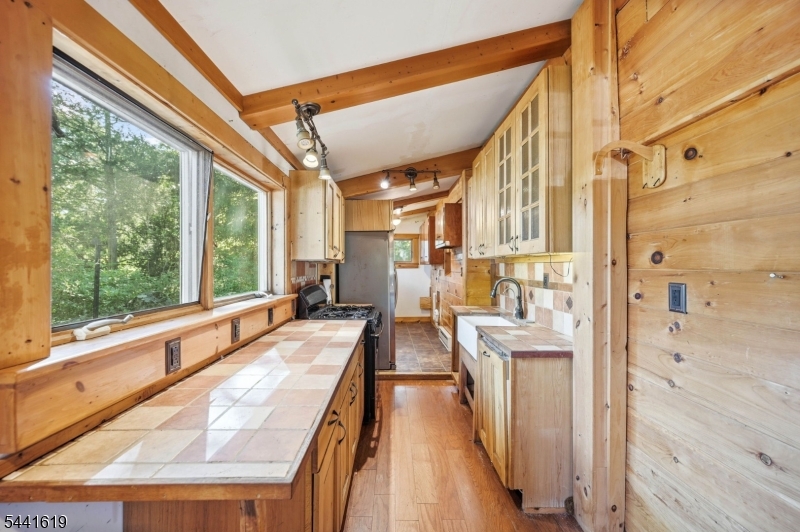 Tucked Away In Shady Lake In Lower West Milford, This 2 Bed, 1 Bath Log Cabin Offers The Perfect Escape From The Everyday. This Home Blends Rustic Character With Year-Round Comfort. Inside, You'll Find A Stone Fireplace Featuring A Wood-Burning Stove Insert That Creates The Perfect Cabin Atmosphere. The Galley-Style Kitchen Offers Cabinetry, Tile Countertops, And Convenient Laundry Hookups. 2 Bedrooms Provide Comfortable Accommodations For Weekend Getaways Or Full-Time Living. Outside, Enjoy The Privacy Of A Wooded Setting, Detached One-Car Garage, And The Surroundings That Make This Property Feel Like A True Retreat. Whether You're Looking For A Weekend Hideaway, A Nature Lover's Escape, Or An Affordable Year Round Residence, This Property Offers Exceptional Value With Low Taxes And Endless Recreational Opportunities Nearby. Located Near Major Highways While Still Feeling Worlds Away. Enjoy Nearby Wineries Throughout The Hudson Valley, Boating And Hiking In The Surrounding Lakes And Forests, Skiing And Snowboarding At Mountain Creek, The Mountain Creek Water Park, Local Restaurants, Farm Markets, And Year-Round Outdoor Recreation. No Short-Term Rentals Permitted. Optional Shady Lake Membership Provides Access To: Olympic-Size Swimming Pool, Private Lake Access, Clubhouse, Volleyball Courts, Playground, Tree Farm & Hiking Trails.  Schedule Your Showing Today!