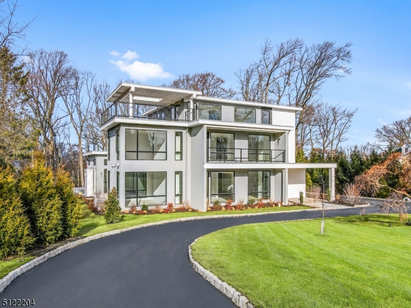 This new construction custom contemporary home is one-of-a-kind, an exhilarating 7 bedroom 7 1/2 bath modern architectural masterpiece nestled on nearly 1.2 lush acres boasting a stunning open concept floor plan with soaring ceilings and walls of windows. This home offers multiple lofts, balconies and terraces, an elevator to all four floors, several office options, Pella contemporary windows and doors, California Closets, Restoration Hardware chandeliers, 10' ceilings on the first floor and a gourmet kitchen with Wolf, Sub-Zero and Miele appliances. The bedrooms are generously sized with en-suite baths for all and an enviable primary bedroom suite featuring a custom walk-in closet and spa-like bath with heated floors and views of the impressive rear property. A third floor with loft, bedroom, full bath and two rooftop terraces is a wonderful surprise as is the expansive lower level featuring a well-appointed wine cellar with Sub-Zero wine/beverage refrigeration, an exercise room and space for a home theater and recreation center. Step onto the rear loggia and marvel at the built-in heated pool/spa with automated cover and the private deep property with mature trees and vegetation. A second-floor laundry, sophisticated systems and three-car heated garage with electric car charger all add to this home's cachet. Close to the highest-rated public and private schools in NJ, the renowned Mall at Short Hills and transportation to NYC, this home will not disappoint.