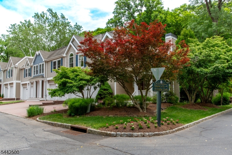 Welcome to Rock Creek Woods, where comfort, natural beauty, and convenience come together in one exceptional home. This stunning corner-unit townhome offers a peaceful retreat surrounded by mature trees and lush landscaping. A charming mahogany front porch welcomes you home and sets the tone for the warmth and character found throughout. The first floor features beautiful hardwood flooring and a spacious living room centered around a cozy gas fireplace, creating the perfect setting for relaxing evenings. The thoughtfully designed layout flows seamlessly into the kitchen. A large first-floor powder room adds convenience for both residents and guests. Double French doors and a dramatic wall of glass lead to an expansive deck, offering beautiful views and the perfect place to enjoy your morning coffee, dine outdoors, or entertain while taking in the surrounding scenery. Upstairs, the spacious primary suite serves as a private sanctuary. The bedroom features French doors opening to a charming Juliet balcony with lovely views, while the ensuite bathroom offers a double sink vanity and generous walk-in closets. Two additional bedrooms provide excellent closet space and are served by a full hall bathroom. As an end-unit property, this home enjoys enhanced privacy and an abundance of natural light from multiple exposures. A two-car garage, double-width driveway, and ample guest parking provide plenty of room.