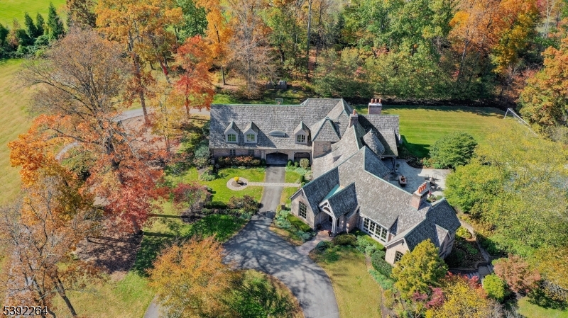 Designed by award winning NYC based architect Jeffrey Beers and featured in NJ Home magazine, this extraordinary stone manor estate is the pinnacle of refined, luxury living. Set on 12 picturesque acres, the 5 bedroom & 6.2 bath residence showcases premium craftsmanship & dazzling architectural details, including dimensional ceilings, custom doors/windows, designer tile & high end fixtures.  The main level impresses with a grand foyer/sweeping staircase, dramatic formal dining room with bespoke built-ins, spacious living room with barrel-vaulted plank ceiling & private BR suite. A desirable floor plan includes abundant windows with natural light & breath taking views throughout.  A chef's dream kitchen features professional-grade appliances, dual oversized marble islands, custom lighted cabinetry, a window-lined banquette, butlers pantry, & adjacent wet bar.  Upstairs, the stunning primary suite features a gas fireplace, dual walk-in closets, & spa-like bath.  Two additional bedrooms are spacious with ensuite baths & generous closets and a fourth bedroom suite offers a separate entrance. The walkout lower level is impeccably finished with built-ins, wet bar, home theatre, rec room & full bath. From a scenic pond to a resort-style heated pool, the private & manicured grounds offer an unparalleled retreat for outdoor living. With a Far Hills mailing address, this one-of-a-kind residence is minutes away from premier Basking Ridge Schools, shopping & major highways.
