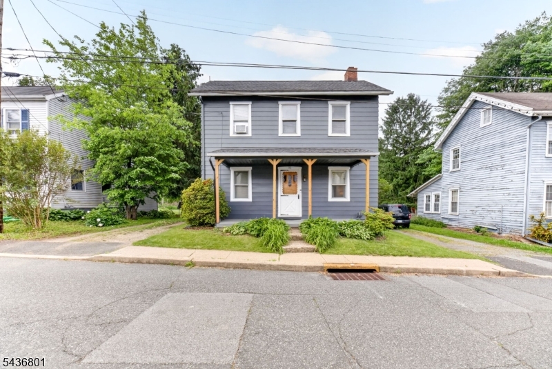 Welcome to this well-maintained 2-3 bedroom, 1-bath detached Colonial located in Bloomsbury, NJ. This move-in ready home features beautiful hardwood floors throughout the living room, dining room, and upstairs bedrooms. The spacious eat-in kitchen offers a brand-new gas stove, dishwasher, and ample space for everyday dining. A walk-up attic provides additional storage potential, while the basement includes a washer and dryer (approximately 1 year old), dehumidifier, and utility area. Major updates provide peace of mind, including a new septic system installed in 2023, replacement windows, and a tankless on-demand gas boiler/water heater approximately 4 years old. Public water service is connected. Outside, enjoy a fenced backyard featuring a mature apple tree, gardening space, and a storage shed. Off-street parking is available behind the home with space for approximately 3-4 vehicles, plus an additional 1-2 cars in the driveway. Conveniently located near the scenic Musconetcong River, this charming home combines small-town appeal with modern updates.