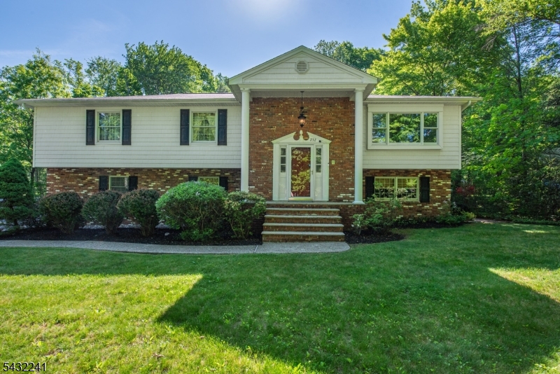 Expanded Custom Built Bi-Level features front and back staircases. One owner who designed and personally general contracted the construction of this home. Situated on a level 1.8 acre with open lawn, woods and a pond in the rear of the yard. Mature landscaping includes seasonal blooming plants and bushes. Custom oversized eat-in  abundant cabinetry kitchen. Hardwood floors, Central Air, 4 zone heat & central vacuum system. NINE spacious rooms throughout. THREE BEDROOM septic, but there are 5 Versatile rooms that could be used for bedrooms, office, craft room, storage, art room, flex rooms. Three Full bathrooms too!  Master Bedroom features a walk in closet and  ensuite bath. The family room has a brick fireplace and sliding glass doors that lead to a paver patio. Large deck provides additional outdoor entertaining space. Exterior features include  vinyl cedar shakes and brick in the front, and vinyl siding on the remaining sides. Oversized garage with interior access plus a separate door to the backyard and shed.  Expansive driveway accommodates 10 + vehicles. This home is set well back from the road for secluded privacy.