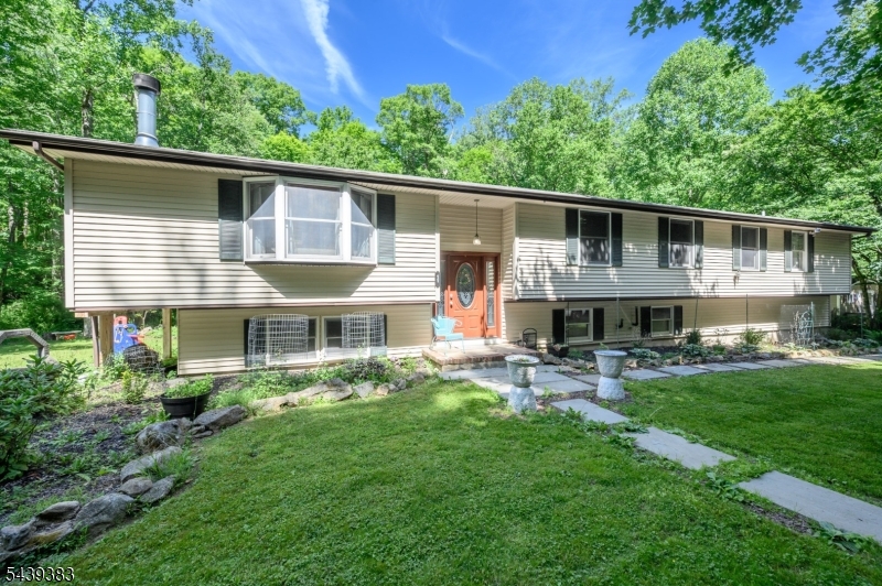 Welcome Home! Custom 4 Bed 2 Bath Raised Ranch situated on over 1.5 acres of plush land offering beautiful views of Hunterdon county's roiling hills could be the one for you! Enter to find a light & bright Living Rm adorned with crown molding, recessed lights, and luxe vinyl plank flooring that extends throughout. Cozy wood burning fireplace is perfect on a chilly night. Formal Dining Rm is a great space for hosting dinner guests with sliding glass door leading to the rear deck for easy al-fresco dining. The Kitchen offers a plethora of cabinetry for storing kitchen needs. Down the hall, the main full bath with tub shower + 4 generous Bedrooms including the Primary Suite. Primary Bedroom boasts a vaulted ceiling with soaring skylight, 2 walk-in closets, a dressing room, and its own private ensuite bath featuring a stall shower and tranquil jacuzzi tub. Partially finished basement holds laundry, utilities, and storage, but finish it off for even more living space. Relax outdoors in the large yard, complete with 2 tier deck, backing to woods offering tons of privacy. 2 car garage & oversized driveway offers plenty of parking for you and guests. Conveniently close to the quaint Town of Califon, dining, & shopping. Enjoy scenic views and hiking on the nearby Colombia trail, fishing in the South Branch of the Raritan River and nearby Ken Lockwood Gorge! Don't wait, this could be the one for you. Come & see TODAY!