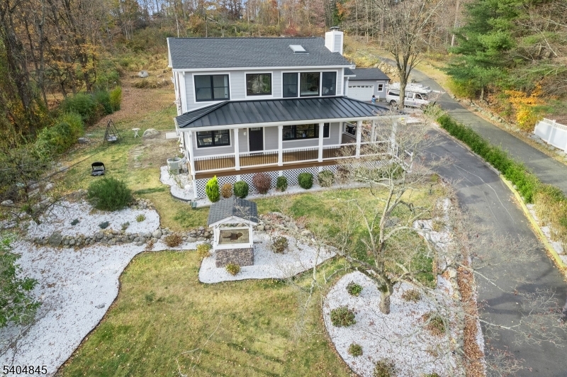 Beautifully updated Colonial w/ modern finishes & open layout, features rich hardwood floors, large windows for plenty of sunlight, elegant crown molding & trim details, & deck overlooking the private backyard, lovely landscaping & brand new pool. Located in Montville Township w/ Boonton mailing address. In the top rated Montville school system. Beyond the wrap-around front porch, the living space flows from the large living room w/ a wood-burning fireplace to the family room & a sunlit formal dining room w/ windows all around. A wide arched doorway brings you into the state-of-the-art kitchen equipped w/ quartz counters, tile backsplash, stainless steel appliances, a breakfast bar, generous cabinetry & full pantry closet. Off the kitchen is a convenient laundry room & a powder room. A doorway to the deck brings you outside to enjoy peaceful privacy in the perfect setting for cookouts, relaxing & entertaining. The second floor has a large primary bedroom suite featuring a vaulted ceiling, a picture window w/ a panoramic view of the countryside, a nice yard w/ a new pool, huge walk-in closet & ensuite bathroom w/ an oversized glass shower. Two additional bedrooms share a full bathroom w/ a dual-sink vanity. To top it all off, a sprawling finished basement offers loads of storage & recreation space. There is also a detached garage & a long driveway for extra parking. Close to major highways, transportation, shopping, parks, schools, & places of worship.