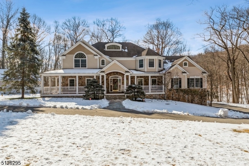 A rewarding escape peacefully situated on three private acres! Spacious and elegant custom Colonial home encompasses 5 bedrooms, 5 1/2 bathrooms, a sprawling wraparound porch and five-car garage (2 attached + 3 bay detached w/all utilities hookups). A welcoming front porch and a large, bright foyer open to the formal dining room with an elegant chair rail and crown molding. The flow continues to the living room and a 1st floor bedroom w/private bathroom. The spacious family room highlights an impressive natural stone fireplace and floor-to-ceiling windows offering scenic views of the property. The heart of the home is the large gourmet kitchen with granite counters, tile backsplash, custom cabinetry, a walk-in pantry and a center island. From the breakfast nook, sliding glass doors open to a large, 3 season FL room with panoramic views. Completing the main level is an office, a powder room and a beautiful deck overlooking the wooded back yard. The second floor includes a luxurious primary bedroom suite featuring a vaulted ceiling, a huge walk-in closet, and an en suite bathroom with double sinks, a soaking tub and separate shower. There are two additional bedrooms with a full Jack-and-Jill bathroom between them, a fourth bedroom with its own private full bathroom, a large exercise room, and a convenient second floor laundry room. The finished basement offers a spacious recreation room, a full bathroom, a mud room with an outside entrance, and abundant storage space.