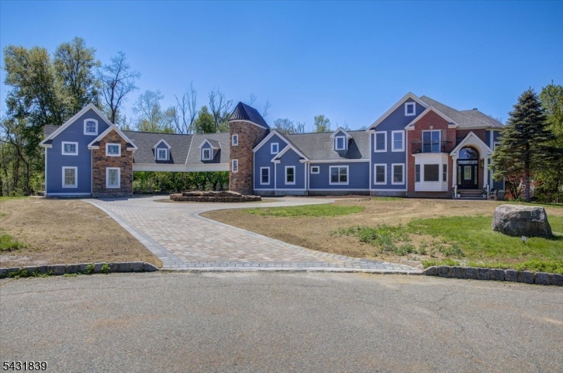 Tucked at the end of a private cul-de-sac on 4.5 acres, enjoy the perfect balance of privacy and convenience, just 7 minutes to Route 80 and about one hour to Manhattan. Thoughtfully expanded with a second-floor addition with HVAC ductwork installed, the home has the potential to reach over 6,000 sq ft once completed. The addition is left in the framing stage, giving the new owner flexibility to create a custom space (home office, in-law suite, art/music studio, etc.) Brand-new 4-car garage features one tall bay designed for a car lift and is pre-plumbed for radiant floor heating. Port-Cochere provides sheltered, illuminated parking. Inside, extensive renovations with premium finishes throughout. Open-concept kitchen with brand-new stainless steel appliances, Cambria quartz counters with brass inlay, and sophisticated two-tone cabinetry. Additional upgrades include new engineered hardwood flooring, detailed crown molding and custom trim, beautiful accent walls, smart thermostats, Tesla charger, and brand new HVAC system. Primary suite is a private retreat with a freestanding soaking tub, large walk-in shower with lighted recessed niche, and dual shower heads. The partially finished basement offers a home theater and dedicated gym. Outside, enjoy a resort-style pool with new pavers. Additional value includes a reserved area for a second septic tank and a new hot water heater with whole-house filtration system. This is a rare opportunity for luxury, privacy, and modern living.