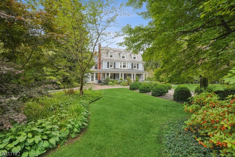 This timeless Dutch Colonial masterpiece, is an exquisite home that has been completely renovated to blend classic elegance with modern luxury. Nestled on 1.16 acres of lush, beautifully landscaped grounds, it is the perfect retreat just blocks from town, train, and top-rated schools. A gracious front porch welcomes you into a grand entrance, where a sweeping staircase with a stunning stained-glass window sets the tone for the impeccable craftsmanship throughout. With 4 finished levels, this home boasts 6 bedrooms, 5 full baths, and 2 half baths. The main level is designed for both grand entertaining and everyday living, featuring a living room, banquet-sized dining room, paneled library or office, and a spacious sun drenched family room. The chef's kitchen is a dream, outfitted with top-of-the-line appliances, a breakfast room, and a mudroom. A rare first-floor bedroom suite with a walk-in closet offers added flexibility.The second level is home to the luxurious primary suite with a spa-like ensuite bath and a large walk-in closet, along with 2 additional bedrooms and a laundry room. The third floor offers 3 more bedrooms and a full bath, while the finished lower level is an entertainer's delight boasting a recreation room, game room, wine cellar, arts and crafts room, ample storage, and a full and half bath. Outside, the private park-like yard is perfect for play, gardening, and quiet relaxation. This is truly a home where classic style and modern comfort are unrivaled.