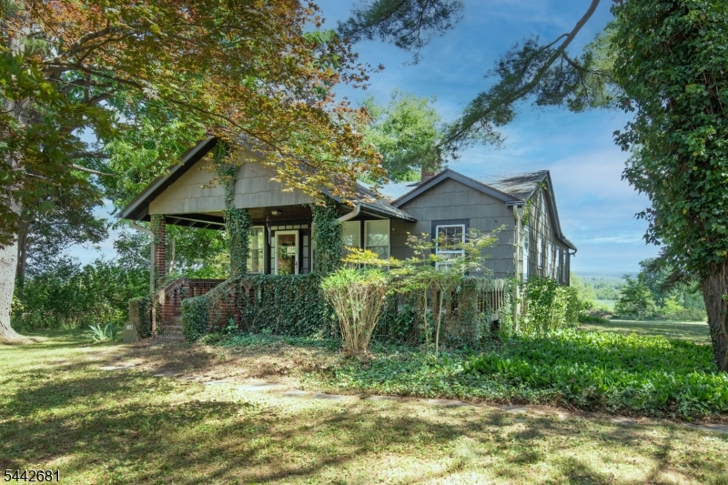 Enjoy country living in this Charming Arts and Crafts style home!  Authentic in its architecture, it features oak hardwood floors, detailed woodwork, handsome living room fireplace.  Amazing spacious front brick porch leads to entry foyer.   The spacious kitchen opens to a family room with walls of windows and a scenic vista of farmland and the mountains!  A private hallway leads to two bedrooms, full bath and large closet/possible office.  This home provides one floor living.   A bonus is the large full basement and detached oversized garage all set on almost an acre!  Room sizes approximate. This is an 'as-is' sale.  There is documentation for a newer septic and also a clean tank sweep!   Can accommodate a quick closing if needed.