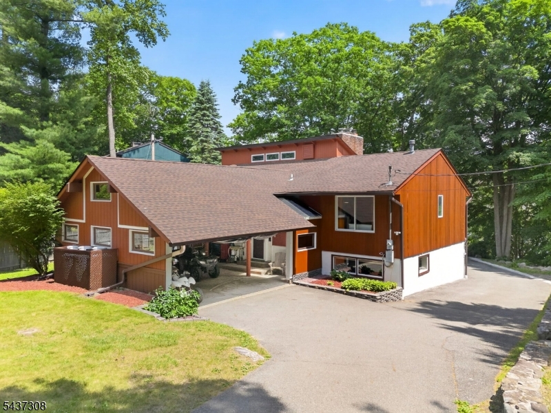 Welcome to this 4-bedroom, 3-bath home perched on a hill with breathtaking views overlooking a beautiful lake community. Situated on nearly half an acre, this property offers the perfect blend of nature, recreation, and opportunity. Enjoy year-round outdoor adventures with easy access to nearby Waywayanda State Park, featuring over 60 miles of trails and a 255-acre lake for hiking, biking, snowmobiling, cross-country skiing, fishing, & more. Mountain Creek Resort is also just a short drive away, offering skiing, snowboarding, a water park, and  mountain biking. Lookover Lake has a private beach, fishing, & social events. The recently painted exterior gives this home fantastic curb appeal & second-floor deck provides an even more spectacular stunning lake view.An oversized rear carport with abundant storage provides plenty of room for all your outdoor gear and recreational toys. Brand-new 6 inch gutters, leaders, leaf guards & roof with a 15-year warranty offers added peace of mind for years to come. Looking for flexibility? This unique home features a desirable mother/daughter-style layout, offering space for extended living arrangements, guests, or additional privacy. If desired, this home can be owner occupied or an investment opportunity. Located in the sought-after Lake Lookover community with convenient access to shopping & dining. Lake living, mountain adventures, and unforgettable million-dollar views. Come experience it for yourself. You don't want to miss this one!