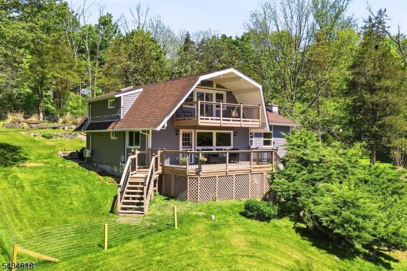 Welcome to the perfect blend of country charm and modern updates in scenic Stillwater. Set on a peaceful 2+ acre property surrounded by nature, this beautifully updated home offers a true retreat close to Historic downtown Stillwater plus only 12 minutes to Newton w shopping, restaurants, theatre, and everyday conveniences like Starbucks, Panera, and big box stores. Inside, the spacious floorplan is filled with country character like wood ceilings, exposed beams, and a stunning stone wood burning fireplace anchoring the oversized family room with dramatic floor-to-ceiling windows. The renovated kitchen features brand new appliances and cabinetry, abundant counter space, and a deep stainless steel sink overlooking the backyard w sliders lead to the new paver patio. A dining area off the kitchen, renovated laundry room w half bath, formal living room, and mudroom/foyer area ideal for a home office complete the first floor. Improvements in the last 2 years include NEW kitchen and appliances, flooring, interior painted , interior doors, updated electrical and lighting, repaired chimney, four mini splits, paved driveway, sump pump, fencing, and more. Upstairs features a spacious primary bedroom with oversized closet and private deck overlooking the picturesque property along with two additional bedrooms and an updated tiled full bath with tub/shower. 2 garage bays, fenced backyard, and a large front deck perfect for morning coffee while enjoying the peaceful front yard.
