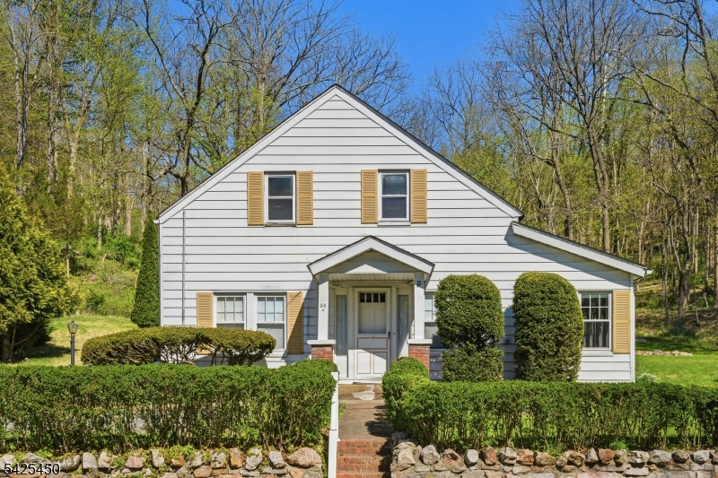 A rare opportunity in the heart of Peapack. Set on nearly an acre, close to Natirar Park, Peapack village dining, and a four minute walk to the direct NYC train line - this property offers a lifestyle that feels both connected and quietly removed. Loaded with future upside, including potential additional bedroom expansion on the second level. Surrounded by serene trees and expansive grounds, the setting feels peaceful and tucked away while remaining close to the charm of Peapack-Gladstone's shops and commuter conveniences. The home features sun-filled living spaces, hardwood flooring, an original fireplace anchoring the living room, and a flexible layout designed for both everyday living and quiet retreat. A bright screened-in porch and secondary prep kitchen add warmth and character, while a detached outbuilding and storage shed offer additional versatility and future possibilities. The upper level provides additional unfinished space currently utilized for storage, offering flexible space and potential for future customization. Gas service has been run to the property, providing added potential for future utility connections. Whether restored, expanded, or simply enjoyed as it is, the true distinction of this property lies in its rare combination of land, location, and opportunity in one of Somerset County's most desirable communities.