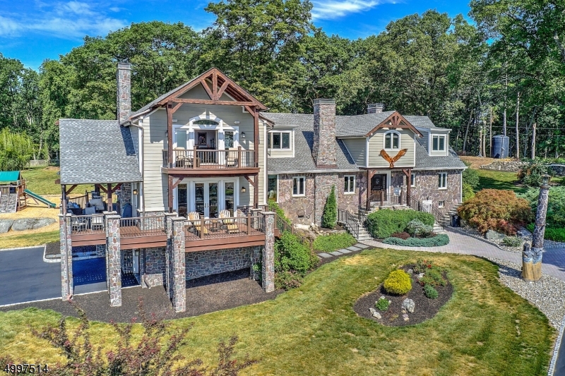 Once you enter this privately gated mountain top retreat you feel the privacy and peace of this one of a kind property. Exterior features pudding stone,wrap around decks & barn wood beams 5700 sq ft home features 2 master bdrms 1 on 1st fl and 1 on top floor private deck with beautiful sunrise views of NYC skyline. Chef s kitchen has built in Miele coffee/espresso machine, pull drawer microwave and Wolf stove. Large center island and a bow window to bring in natural light. Great room is perfect for entertaining with gorgeous custom wet bar, custom woodwork including coffered ceiling and stone fireplace. Leads to covered deck with outdoor fireplace, TV and music system. Large fire pit with music system backlit by NYC skyline view. Kinnelon has been rated 1 of safest towns in NJ. Public schools are top rated.