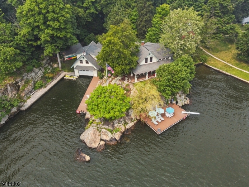 "CRAIG THISTLE" - a truly rare island retreat w/Guest House on Raccoon Island, set on iconic Lake Hopatcong, New Jersey. This enchanting circa 1890s painted beauty sits proudly at the island's south-facing point, capturing amazing sunsets, expansive water views, and timeless character. Accessible by private boat or ferry, the main residence offers 4 bedrooms and 2 baths (yes-there's even a classic outhouse), an original living room with wood burning fireplace, dining area, and kitchen, recently added expansive great room and 1st floor primary suite, all accented by original stained-glass windows and historic accents. Covered porches, patios, an outdoor bar and shower, and extensive Trex-style decking create exceptional indoor-outdoor living.The property also features ample boat and car parking, a two-story boathouse with bunkhouse nestled in a striking private cove, a separate Guest Cottage with 1 bedroom, bath, and kitchenette, and a two-car garage, all tucked away in serene natural privacy. Offered completely furnished, Craig Thistle is a once-in-a-generation opportunity to own a storied island estate.  Island is accessible via seasonal car ferry. Vacation where you live!