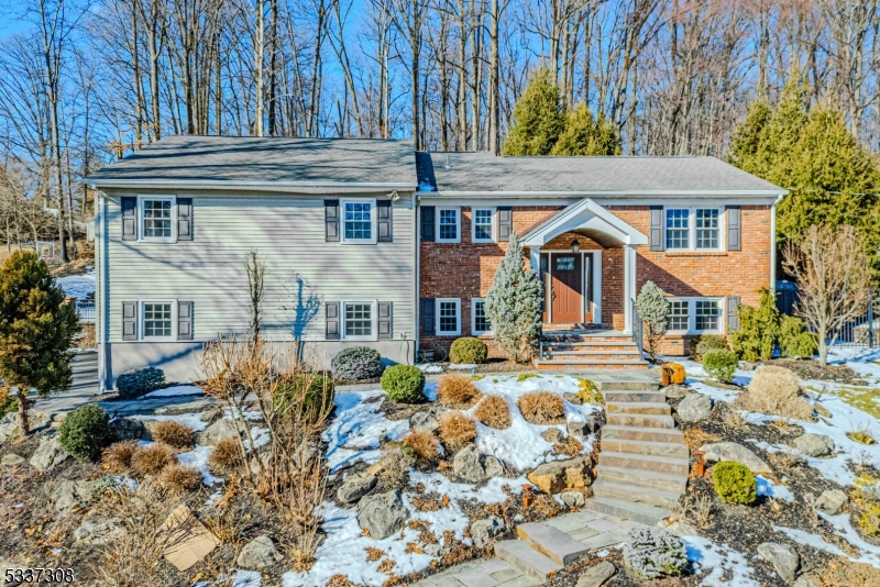 Immaculate, Bright Custom Bi-Level. Quality craftsmanship and fine detailing throughout. Situated on an expansive lot, in a quiet Neighborhood. Gorgeous bluestone hardscape welcomes you in. Lots of Generous Room Sizes to Spread Out & Make Your Own! Layout offers versatile options! GREAT house for entertaining or everyday living. Large living room w/big picture window offers tons of natural light. Recently renovated custom kitchen. Granite countertops, maple cabinets, stainless steel appliances, gas cooking & separate dining area. 4 large bedrooms & 2 full bath upstairs includes the primary suite w/bath & walk-in. 2 additional bedrooms and bath on lower level offers more room for guest or multigenerational living. Fully equipped w/an optional exercise room or office & laundry/mudroom. An oversized family room w/projector & screen adds to the fun and functionality. Over 3100 square feet. 2 car garage. The property offers breathtaking gardens and an amazing backyard, fully fenced with a patio & deck. Low voltage exterior lighting for ambiance. Underground irrigation system. Enjoy a game of basketball on your private sports court. Tons of parking! Almost a full acre. An ideal spot to relax & enjoy life. Both gutters & roofs have a heated de-icing system.  Just a short walk to Downtown Morris Plains & NYC Direct Train Station. Or a short drive to Morristown Green, Dwtn Denville, tons of shopping and restaurants! Easy access to major highways such as 80, 10, 46 & 287.