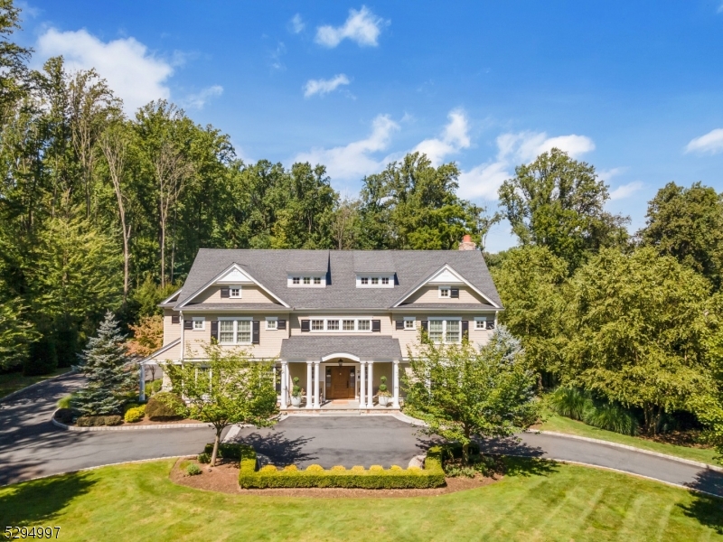 Nestled in Morris Township, this residence stands as a beacon of luxurious living, sprawling across 2.11 acres of beautifully landscaped grounds. This distinguished home marries classical architectural beauty with modern-day comforts, creating an ambiance of refined elegance. The grand foyer sets the stage with its soaring ceilings and intricate detailing, complemented by the warmth of natural light that plays across polished hardwood floors. Central to the home is a chef's kitchen, outfitted with gourmet appliances and an expansive island, making it a hub for culinary exploration and social interaction. The home is meticulously designed to cater to both lavish gatherings and private moments, featuring 5 bedrooms, 5 full and 2 half baths, offering ample accommodation for residents and guests. The primary suite serves as a tranquil retreat, complete with a spa-like bathroom and custom walk-in closets. A unique feature is the third-floor golf simulator, offering a distinctive leisure experience. The home also includes multiple leisure spaces, a dedicated home office, a pool cabana with full bath and an oversized 3-car garage. The outdoor areas extend the living experience, with a heated pool with retractable cover and spacious patios set against the backdrop of the estate's verdant surroundings. Van Beuren Manor is a sanctuary of sophistication and comfort for those who seek an unparalleled living experience.