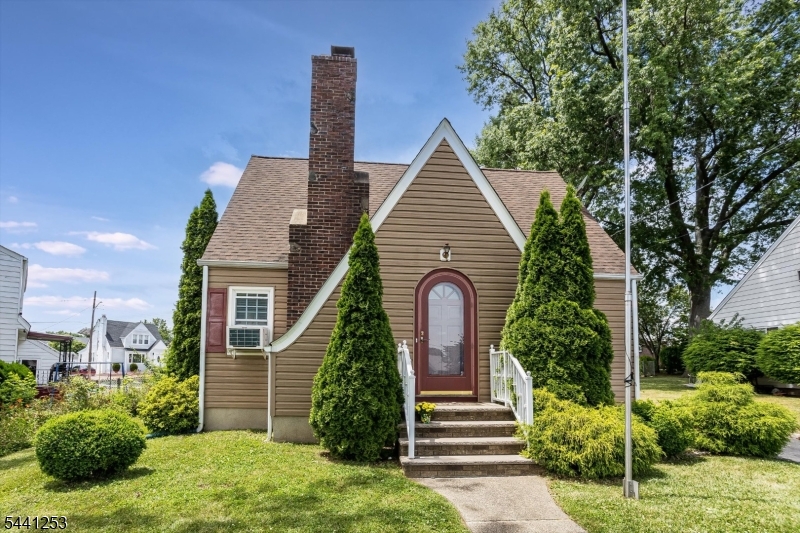 Storybook Charm! This unique Tudor Cape Cod is ideally located on a quiet street in desirable Sunnyside neighborhood. Amazing curb appeal. Vestibule leads to spacious living room featuring gleaming hardwood floor, gas fireplace, and abundant natural light. Window A/C cools entire first floor with ease. Arched doorway leads to formal dining room with sparkling chandelier, hardwood floor, and chair rail molding. The perfect place to entertain! Cooking is a breeze in the updated eat-in kitchen with plentiful cabinet space and countertops. Stylish living room staircase leads to the second floor. Two sunny comfortable bedrooms feature ceiling fans, hardwood floor, a window A/C, and ample closet space. Primary BR has additional cedar closet. Updated bath and linen closet complete the second floor. Kitchen backdoor leads to an inviting 3-season room. Enjoy fresh air while you dine, relax, or entertain in this bright, welcoming space. Step out back to a patio and private, fenced yard with large shed. A detached garage is lined with deep shelves for storage or remove the shelves to park your car. Garage loft adds storage. A partially finished basement offers valuable extra space ideal as a den, playroom, or office. The laundry area, utility room with new furnace and water heater, and storage closets complete the lower level. Short walk to a grocery, shops, and restaurants. Close to schools. Near bus stop and train for easy travel to NYC. A lovely home offering comfort and convenience!