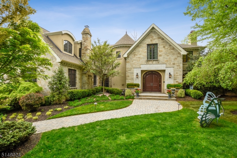You will fall in love with this one-of-a-kind dream home. Tucked away on show-stopping grounds, this architectural gem provides the ultimate in privacy while conveniently located near the heart of it all. Upon entering into the gracious foyer with spectacular marble floors, you'll be greeted by a beautiful winding staircase. A formal living room opens right into an office complete with custom millwork, perfect for working from home. The sun-drenched family room with french doors overlooks the backyard oasis and flows into the gourmet kitchen redone in 2018. The eat-in kitchen features high-end appliances with no expense spared on the tasteful quartzite counter-tops, backsplash and light fixtures. A butler's pantry off the kitchen leads you past one of two powder rooms on the first floor, right into the cozy den complete with a fireplace and bar. The large dining room is ideal for a variety of gatherings. Upstairs, the primary bedroom is sure to impress, featuring a sitting room, luxurious bathroom with separate shower/soaking tub, and walk-in closets. Four en-suite bedrooms round out the second floor. The basement features a large rec room, gym, and additional bedroom en-suite. And that's not all! The resort-style backyard will absolutely blow you away with a heated gunite pool and pool house built in 2014, large travertine patio, outdoor kitchen, and plenty of lush lawn for leisure. Close to town, train and middle school. It doesn't get any better than this.