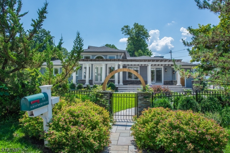 Beautiful, Sprawling, Updated Ranch in the desirable Indian Lake community! Step into this secret garden through a wooden arch and gorgeous gates. Fabulous Open Living Space. Living room with tray ceilings and stone faced gas fireplace.. Bright, Sunny Eat-In-Kitchen w/Granite Counters & High End SS Appliances. French doors to enjoy the qide composite deck with pergola. Large, Welcoming Foyer w/Unique Arched Wooden Door! Gorgeous hardwood flooring & solid custom wood doors and crystal door knobs throughout. 3 generous sized bedrooms equipped with lots of closet space. Grand Primary suite showcases high ceilings, automatic blinds, custom walk-in closet & bath w/oversized spa shower. Main bath features gorgeous tile work & jetted tub. Flexible Finished Room in Basement. Family room, wet bar, laundry & 3rd full bath. 2 Car Garage & TONS of storage! Stunning landscaping and so many extras completed w/quality craftsmanship.  Stones throw from ILCC diving board beach & Bistro. You can't beat the location. Convenient to everything! Just minutes to public transportation -NYC-Direct train & bus, major highways, grocery store & great restaurants/shopping in Downtown Denville.