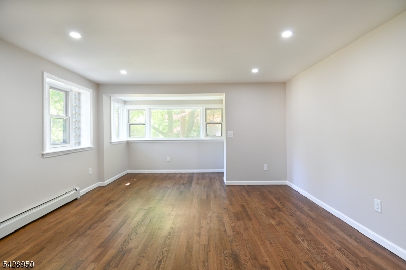 Fully renovated 1st floor apartment! This spacious unit features 2-bedrooms, 1-bathroom, gleaming hardwood floors, a stylish open-concept layout and high-end renovations, plus a privet patio. Enjoy a modern eat-in kitchen, spacious living room, plus a bonus room. Additional perks include: on-site laundry facility, parking space, storage unit, additional off-street parking and ample outdoor green space. The building's central location provides convenient access to public transit, (bus stop is one minute away) major highways, shopping, dining, and parks.