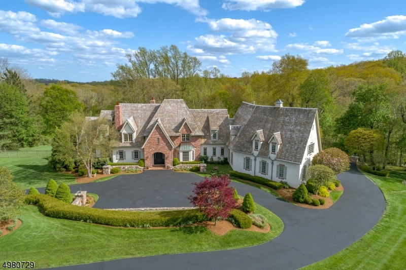 Set atop Crownview Lane on five exquisite acres, this magnificent French-inspired home is at the end of a private cul de sac in highly sought-after Bernardsville, NJ, only 40 miles from Manhattan. The grand living room has 24' ceilings and French doors that open to a covered porch with spectacular views. Floor to ceiling stone fireplace creates a cozy feel in the kitchen/great room. 1st-floor master bedroom suite is a quiet refuge with a spa-like master bath.  Level 2 has 4 en-suite bedrooms, rec room and a guest suite with its own entrance to the 4-car garage. Extraordinary lower level with kitchen, wine, billiard, & media rooms. Bi-fold NanaWall doors open to the reverse osmosis inground pool. Custom stone walls and bluestone patios with a wood-burning fireplace and outdoor kitchen create a lush oasis.