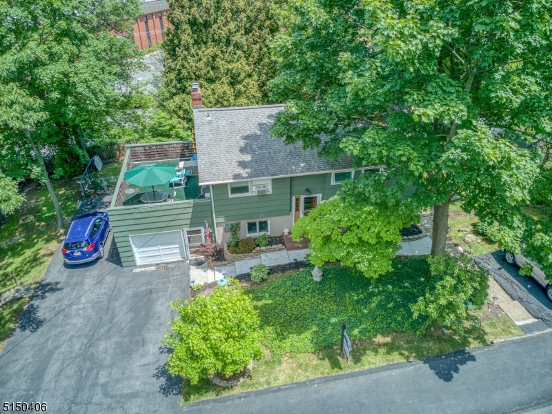 Beautiful custom built bi-level Denville home located on an extra large corner lot. Walking distance to train station, shopping areas, Indian Lake & DWTN Denville. Ideal home for versatile living, virtual home offices & separate entry in-law suite. Lots of space! Lower level has laundry room (washer & dryer included) workbench area, dining room w/ceramic tile floor & coat closet, kitchen w/breakfast bar & SS appliances, 22x13 foot living/great room w/WB fireplace features two sets of sliders that open to a covered deck. Lower level also offers a full bathroom and two additional rooms, one with sliders that open to the backyard. These rooms can be used as bdrms, sitting/play rooms or home offices. Upper level has HW floors. Primary bdrm w/private entrance, full bath w/jacuzzi tub & walk in closet. 3 additional bdrms & a 3rd full bath w/located on the upper level w/lots of closet space & a roof deck off 2 of the bdrms.  This home also offers a 10x10ft shed next to the back deck and a 20x12 ft storage shed w/loft located on the lower yard. 3 driveways & well groomed landscaping. Brand new front walk and outdoor staircase that leads to the primary bdrm suite. Ceiling fans & window AC throughout home. Enjoy lots of land, space, natural light, great neighbors and an outstanding school system. Easy access to route 80, 10, 46 and 287. Fenced in backyard with lots of privacy. 3 year old furnace. Relaxing environment..... But close to everything! Great value for the price.