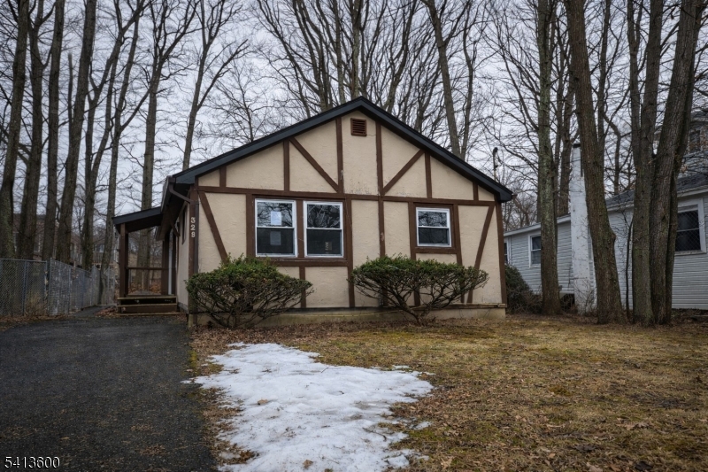 Welcome to 329 Elmira Trail, a Tudor-inspired ranch tucked into a peaceful Hopatcong setting, offering approximately 664 sqft of character, charm, and opportunity. From the moment you arrive, the distinctive exterior detailing and wooded backdrop create a sense of retreat and potential. Step inside to discover a flowing layout where the living and dining areas connect seamlessly, creating an open space ready to be transformed to fit your vision. The kitchen offers a practical footprint with exciting redesign possibilities, ready to become the heart of the home. The comfortable bedroom features natural light and closet storage, while the full bath with stall shower completes the main living quarters. An additional flex space provides versatility for a home office, den, or creative retreat. Outside, the rear deck invites you to design your own private outdoor escape surrounded by trees. Value-add opportunity for investors! Schedule your showing today! Photos are digitally enhanced. Being sold AS IS, WHERE IS, Buyer is responsible for all inspections, CO and certifications. All information and property details set forth in this listing, including all utilities and all room dimensions which are approximate and deemed reliable but not guaranteed and should be independently verified if any person intends to engage in a transaction based upon it. Seller/current owner does not represent and/or guarantee that all property information and details have been provided in this MLS listing.