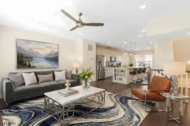 Best Value in Livingston & LOWEST Monthly HOA Fees. Stunning 4 Year Old Townhome, approx. 2000 sq ft of Modern living in the sought-after Livingston Square community. Built in 2021, this home features a flexible floor plan with numerous upgrades, ideal for today's changing lifestyles. The main level showcases an open-concept living, dining, and kitchen area bathed in natural light via oversize windows, upgraded wood floors, a built-in office nook, and a private deck. The gourmet center island kitchen boasts quartz countertops, stainless steel appliances, and a large double pantry. Upstairs are three spacious bedrooms and two full baths, including a luxurious primary suite with two walk-in closets and a tray ceiling. The laundry is conveniently located on the bedroom level. The ground level includes a sunlit office/den (potential 4th bedroom) and access to a 2-car garage with epoxy floors and Tesla charger. Other features include ceiling fans in every room, water softener, reverse osmosis filter, and Container Store closet systems in the 2nd, 3rd bedrooms. The home overlooks a beautifully landscaped green space (largest in the community) with a gazebo. Conveniently located close to train and bus with service to NYC, and within walking distance to Livingston Mall and the express shuttle to S. Orange train station. Close to world-class shopping at Mall at Short Hills, dining, parks/recreation, and top schools. Great Opportunity for Investors or quick move-in!
