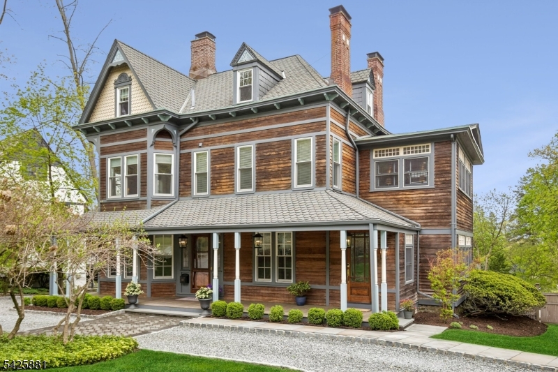 This stunning and iconic 1885 Victorian has been meticulously renovated and thoughtfully reimagined for today's modern lifestyle, blending timeless architectural character with exceptional contemporary updates. Ideally located just one block from Upper Montclair Village, enjoy premier dining, shopping, fitness studios, the historic Bellevue Theatre, the Olmsted Brothers-designed Anderson Park, and bus/direct train service to NYC. Set on nearly a half-acre of beautifully landscaped grounds, the outdoor living spaces are extraordinary, featuring the always coveted welcoming front porch, an expansive new bluestone patio with outdoor kitchen and gas firepit, large deck off the kitchen, privacy fencing, landscape lighting, and new circular front driveway & walkways. This impressive home offers a primary bedroom with luxurious en-suite bath and separate dressing room, 5 total bedrooms, 3 full baths, 2 half baths, & 5 fireplaces. Recent interior renovations include a designer kitchen with center island, Sub-Zero and Wolf appliances & walk-in pantry, three renovated baths, new Pella Architectural Series windows, new hardwood floors and carpeting, new interior doors, and new recessed lighting throughout (and so much more). A spectacular vaulted great room on the 3rd floor provides incredible bonus & flexible living space. Complete with a detached "gingerbread"  two-car barn garage, this is a rare opportunity to own one of Montclair's truly special homes.
