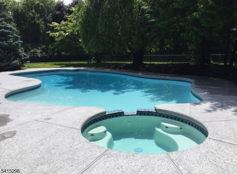 Set behind a long, private approach and surrounded by mature trees, this exceptional 4-bedroom, 4-bath residence offers a rare combination of privacy, space, and timeless comfort in one of Boonton Township's most desirable settings.Step inside to dramatic, light-filled living spaces featuring soaring ceilings, skylights, walls of glass, and a striking fireplace. Designed for today's lifestyle, the flexible floor plan offers multiple gathering areas, a finished lower level, and spaces ideal for work, relaxation, and entertaining.Outside, expansive lawns, peaceful wooded surroundings, and a solar-heated in-ground pool create a private retreat while extending the swimming season through energy-efficient operation. A whole-house backup generator provides year-round peace of mind, keeping the home fully operational during unexpected power outages.Extensively maintained and thoughtfully improved, this home reflects a level of stewardship that is increasingly rare. Offering exceptional privacy, convenient access to major highways, shopping, dining, recreation, and the opportunity to attend the highly regarded Mountain Lakes High School, this is more than a home it is a lifestyle defined by privacy, comfort, resilience, and the freedom to enjoy every season.Whether relaxing poolside, entertaining friends, or simply enjoying the peace and beauty of the natural surroundings, this home offers an exceptional lifestyle both inside and out.
